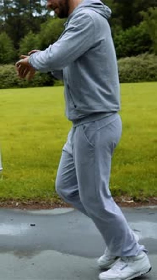 Vertical of Man Running in Forest Woods Training and Look at Computer Clock on His Arm