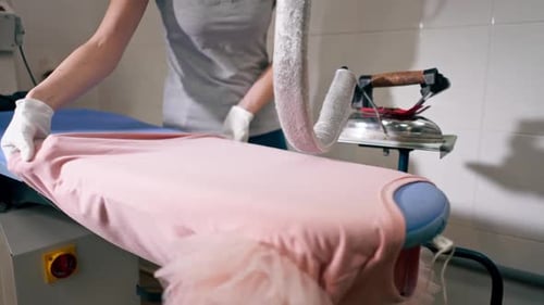 Woman Ironing Pink Garment with Professional Steam Iron
