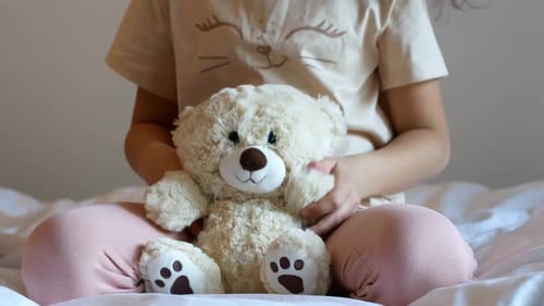 Girl on Bed Hugging Stuffed Teddy Bear