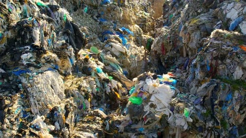 Drone view of huge heaps of pressed garbage at waste sorting plant. Slow motion