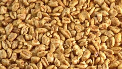 Rotierender Hintergrund aus geröstetem süßem Puffweizen von oben. Trockenes Frühstück, um neue Energie zu tanken
