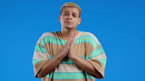 Man Clasping Hands in Prayer on Blue Background