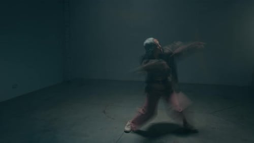 Young Woman Dancing under Strobing Lights with Motion Blur