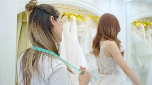 Proprietários de estilistas ou lojas de vestidos de noiva tentam ajudar a escolher um vestido de noiva e experimentar um vestido de noiva.