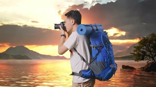 Side View Of Asian Male Hiker Using A Camera Taking Picture At A Lake