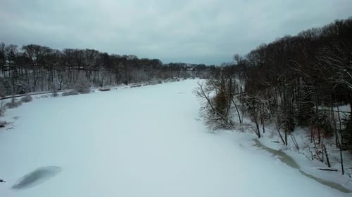 Static shot of Frozen creek in surrounded by forest and rocky mountains