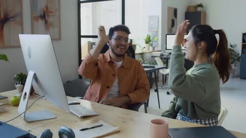 Desenvolvedores árabes do sexo masculino e asiático dando cumprimentos em teste bem-sucedido