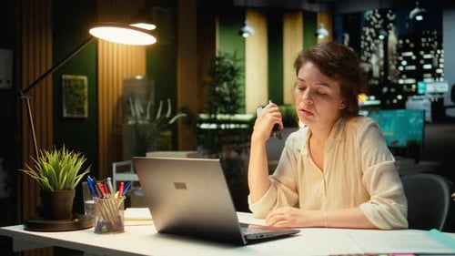 Woman Working Late in an Office, Uses Stapler