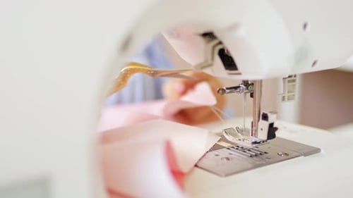 Woman clothing designer sews fabrics on a sewing machine. Needlework