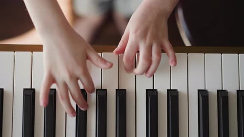 Child Plays Piano Keys Close Up Shot