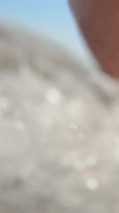 Feet on the beach close-up. The wave beats on the legs and the camera goes under the water. Vertical