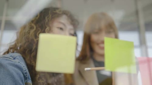 Women Collaborating Using Sticky Notes in Office