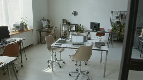 Modern Office Featuring White Table with Laptop Displaying Spreadsheet