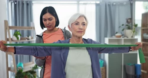 Woman Stretching Resistance Band With Trainer At Home