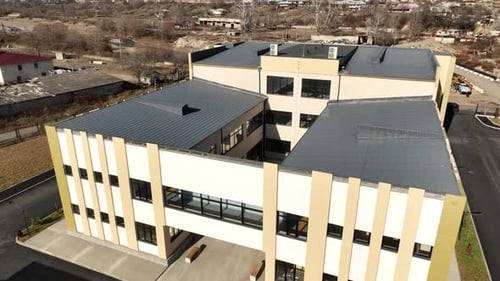 Aerial shot of a contemporary school facility featuring a red and green outdoor sports court