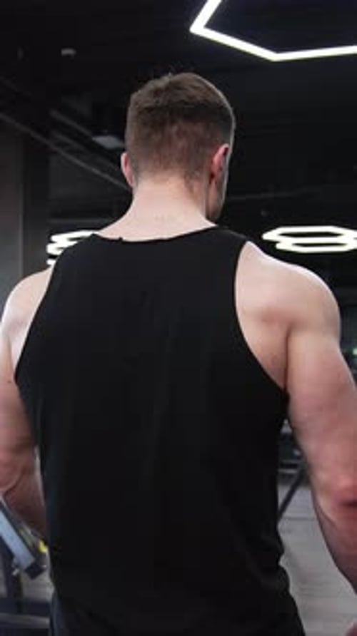 Homem atlético andando em um moderno centro de fitness.