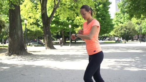 Woman Checking Pulse on Smartwatch After Jogging in City Park 30s