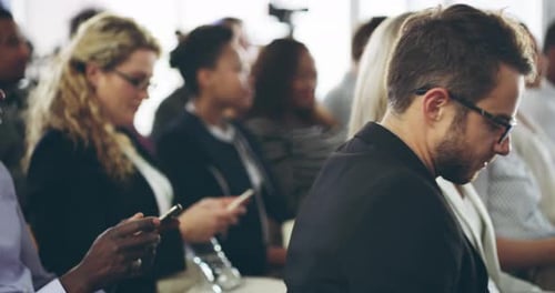 Group of business people sitting in rows at a meeting, seminar or conference in a convention center