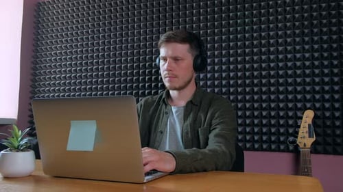 Sound Designer Working on Notebook in Music Studio