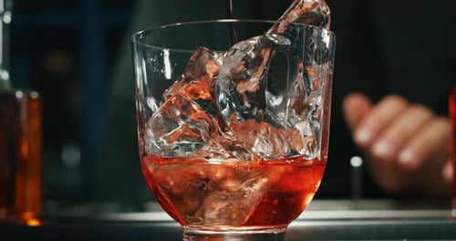 Close up of a professional bartender is preparing an alcoholic cocktail with professional crystal