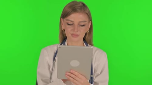 Portrait of Female Doctor Using Digital Tablet on Green Background