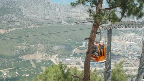 The cable car, the red funicular, takes people down and up the mountain. Sea with city and forest in