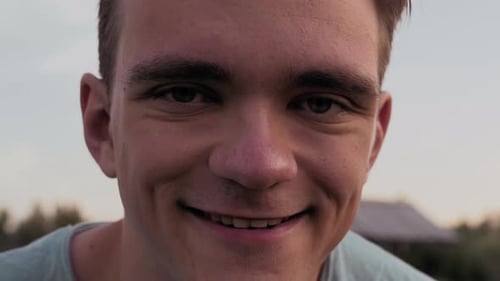 A Young Guy's Face Is CloseUp From Behind Against The Background Of A Lake