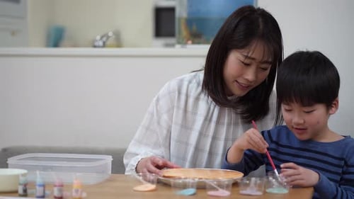 Mother and Child Painting Together at Home