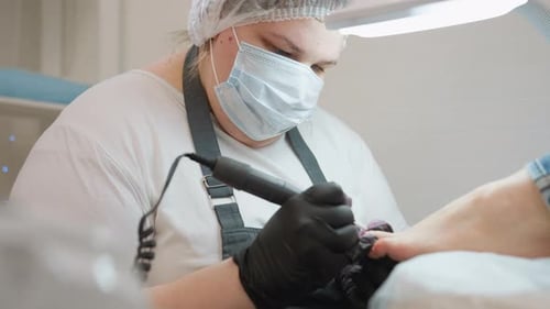 Technician Works on Toenails with Drill