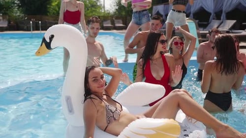 Female and Male Models Chilling in Swimming Pool Splashing Water Flirting and Posing for Photoshoot