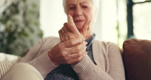 Senior Woman Massaging Her Wrist in Home Setting