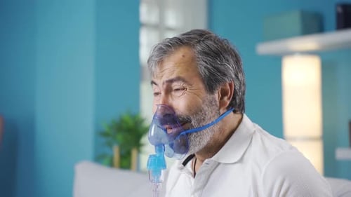 Homme atteint d'une maladie pulmonaire ayant de la difficulté à respirer. Connecté à un respirateur.