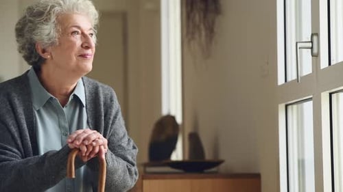 Smiling Senior Woman Leans on Cane Indoors