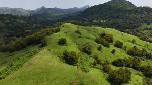 Majestic Aerial View Of Rolling Green Hills And Lush Mountains