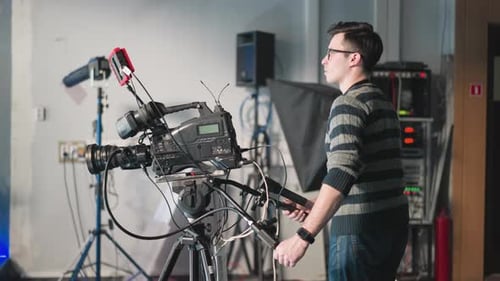 Man Operating Professional Video Camera in Studio Setting