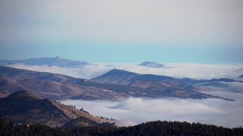 Mountains Overlooking Misty Valley on Bright Day