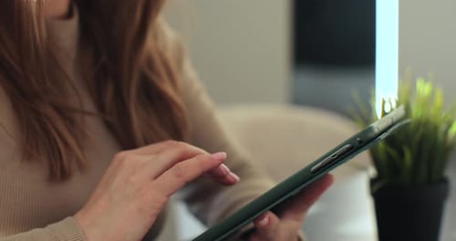 Close Up View of Woman Holding Digital Tablet in Hands Using Apps Typing Studying Online at Home
