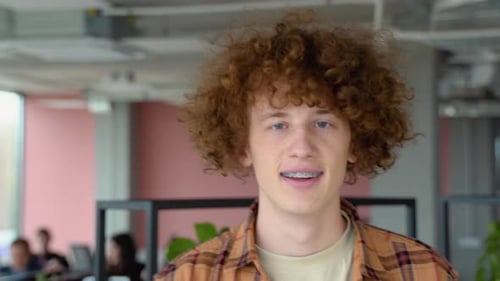 Happy Redhead Male Freelancer with Braces Smiling at Camera and Walk in Co Working Space