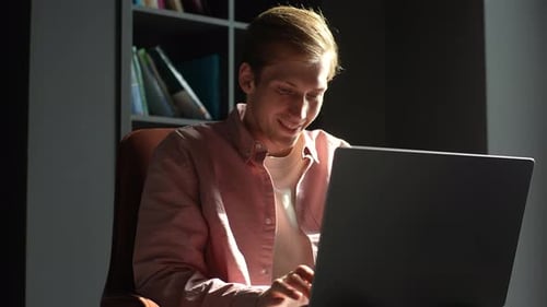 Young Adult Man Working on Laptop at Home