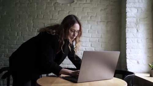 Young Woman Working on Her Laptop Computer in Coffee Shop