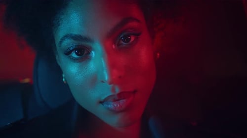 Stylish Woman with Makeup Glares in Moody Lighting