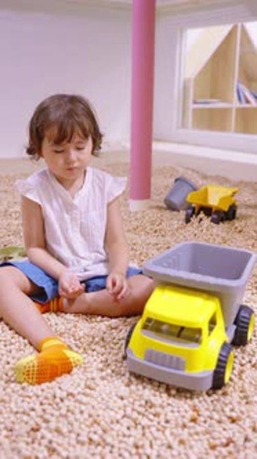 Child Playing with Toy Truck in Ball Pit