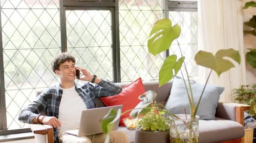 Man Using Laptop and Phone at Home