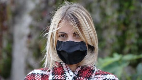 Young Woman Wearing Face Mask Stares at Camera