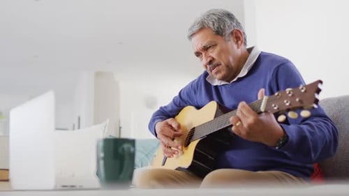 Man Learning Guitar in Living Room