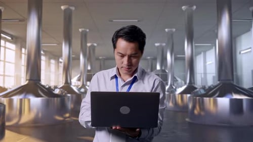 Asia Male Worker Is Working With A Laptop at Beer Plant