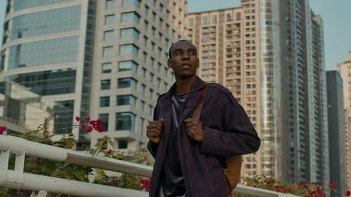 Black foreign student walking around city with backpack, exploring town