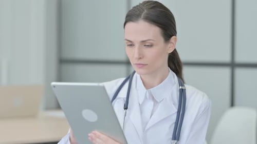 Female Doctor Uses Tablet in Clinical Setting