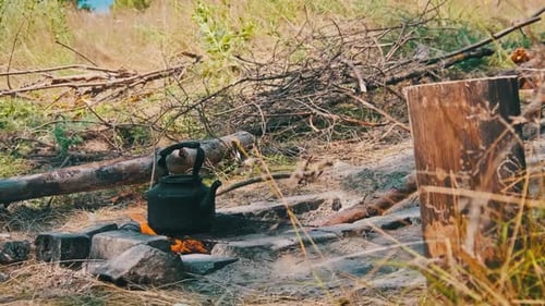 Teapot Steaming on an Open Campfire in Nature