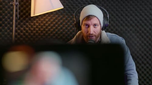 Hipster looking influencer talking to camera in live session in home studio. Professional vlogger or